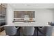 Elegant kitchen island with quartz countertops, stylish barstools, and modern fixtures at 10186 Zeta Tucana St, Las Vegas, NV 89143
