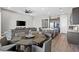 Open concept living room with a modern kitchen, sleek island, and a cozy dining area for seamless entertaining at 10186 Zeta Tucana St, Las Vegas, NV 89143