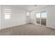 Bright, carpeted bedroom with sliding door access to balcony at 10328 Apefly St, Las Vegas, NV 89141
