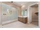 Elegant bathroom featuring a glass-enclosed shower, a vanity with a large mirror, and access to the walk-in closet at 128 Los Cabos Dr # 202, Las Vegas, NV 89144