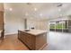 Modern kitchen island with stainless steel sink and faucet, and quartz countertop with adjacent patio view at 128 Los Cabos Dr # 202, Las Vegas, NV 89144