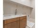 Laundry room with a white sink, wooden cabinets, and tile floor at 128 Los Cabos Dr # 202, Las Vegas, NV 89144