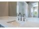 Bright bathroom with a white countertop, modern faucet, and a large mirror reflecting the shower at 128 Los Cabos Dr # 302, Las Vegas, NV 89144