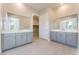 Modern bathroom with dual vanities, tile flooring and a walk-in closet entrance at 128 Los Cabos Dr # 302, Las Vegas, NV 89144