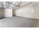 Spacious three-car garage featuring white walls, concrete floor, and three windows at 128 Los Cabos Dr # 302, Las Vegas, NV 89144