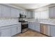 Modern kitchen with sleek gray cabinets, stainless steel appliances, and elegant backsplash, offering style and functionality at 1700 Ivanhoe Way, Las Vegas, NV 89102