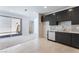 Open-concept kitchen with stainless steel appliances, dark cabinetry, and light-colored tile flooring at 1801 Flycatch St, Las Vegas, NV 89138