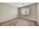 Empty bedroom with neutral carpet, a window with blinds, and light-colored walls at 189 Paxon Hollow Ct, Las Vegas, NV 89148