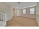 Spacious living room featuring tile flooring, large windows, neutral walls and a staircase at 189 Paxon Hollow Ct, Las Vegas, NV 89148
