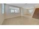 Bright living room with tile flooring, neutral walls, large windows, and a staircase leading to the second floor at 189 Paxon Hollow Ct, Las Vegas, NV 89148