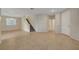Open-concept living area with tile floors, neutral paint, a staircase, and access to other rooms at 189 Paxon Hollow Ct, Las Vegas, NV 89148