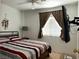 Comfortable bedroom features a window, ceiling fan, and neutral paint at 213 Luninborg St, Henderson, NV 89074