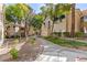 Building exterior displaying a walkway, mature trees, manicured lawns, and well-maintained landscaping at 2251 Wigwam Pkwy # 424, Henderson, NV 89074