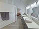 Bathroom showcasing double sinks, a long quartz countertop, modern fixtures, and a door to the bedroom at 2530 Commercial Dr, Pahrump, NV 89048