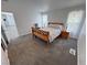 Cozy bedroom with neutral carpet, light walls, windows with decorative curtains, and an adjacent door at 2530 Commercial Dr, Pahrump, NV 89048