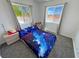 Bedroom view with carpet floors, two windows and a galaxy themed bedspread at 2530 Commercial Dr, Pahrump, NV 89048
