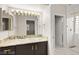 Bathroom vanity with dark wood cabinets, light granite counters, decorative lighting, and access to the shower at 2608 Sun Reef Rd, Las Vegas, NV 89128