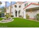 Stunning home exterior with elegant architectural details, a lush lawn, and mature trees at 2608 Sun Reef Rd, Las Vegas, NV 89128