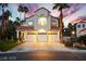 Inviting three-car garage home with manicured lawn and picturesque sunset backdrop at 2608 Sun Reef Rd, Las Vegas, NV 89128