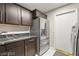 Functional laundry room with modern stainless steel refrigerator and dark wood cabinets at 2608 Sun Reef Rd, Las Vegas, NV 89128