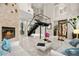 Spacious living room with high ceilings, fireplace, modern staircase, and sleek white furniture at 2608 Sun Reef Rd, Las Vegas, NV 89128
