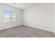 Bright bedroom with neutral carpet, white walls, and large window at 2721 Avril Point St, Las Vegas, NV 89156