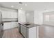 Well-lit kitchen with stainless steel appliances, island with sink, and wood-look floors at 2721 Avril Point St, Las Vegas, NV 89156