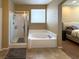 Bright bathroom featuring a soaking tub, a glass enclosed shower, and a tiled floor at 2772 Brinkley Manor St, Laughlin, NV 89029