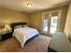 Comfortable bedroom with carpet floors, a large bed, and access to the backyard at 2772 Brinkley Manor St, Laughlin, NV 89029