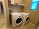 Well-lit laundry room features a stacked washer and dryer and a shelf for storage at 2772 Brinkley Manor St, Laughlin, NV 89029