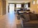 Open-concept living space with tile flooring, seamlessly connecting the living, dining, and kitchen areas at 2772 Brinkley Manor St, Laughlin, NV 89029