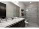 Modern bathroom with double sinks, granite countertops, and a walk-in shower with a built-in bench at 29 Costa Tropical Dr, Henderson, NV 89011