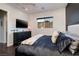 Comfortable bedroom featuring a large bed, dresser, TV, and scenic mountain views from the window at 29 Costa Tropical Dr, Henderson, NV 89011