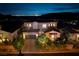 Stunning two-story home with lush landscaping and a view of the Las Vegas skyline at night at 29 Costa Tropical Dr, Henderson, NV 89011