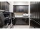 This laundry room features stainless steel washer and dryer, dark wood cabinets and granite countertops at 29 Costa Tropical Dr, Henderson, NV 89011