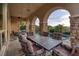 Covered outdoor dining area with stone columns, tile flooring, and a view of the pool and palm trees at 29 Costa Tropical Dr, Henderson, NV 89011