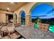 Outdoor dining area with stone columns, a swimming pool, and city views in the background at 29 Costa Tropical Dr, Henderson, NV 89011