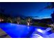 Luxury pool featuring underwater lighting and lounge chairs, set against a backdrop of palm trees and city lights at 29 Costa Tropical Dr, Henderson, NV 89011