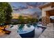 Stunning outdoor pool area with spa, poolside firepit and lush landscaping offering serene sunset views at 29 Costa Tropical Dr, Henderson, NV 89011