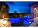 Backyard pool and spa area with lush landscaping, stone accents, and mountain views at 29 Costa Tropical Dr, Henderson, NV 89011