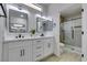 Modern bathroom featuring double sinks, white cabinetry, and a glass-enclosed shower at 2905 Legend Dr, Las Vegas, NV 89134