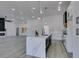 Modern kitchen with white cabinetry, island, and open layout to the living area with fireplace at 2905 Legend Dr, Las Vegas, NV 89134