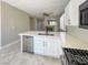 Modern kitchen with stainless steel appliances, white cabinets and a sink overlooking the living area and fireplace at 3532 Mountain Park St, Las Vegas, NV 89129