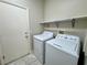 Bright laundry room featuring a washer, dryer, and a convenient storage shelf at 3532 Mountain Park St, Las Vegas, NV 89129