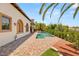 An expansive backyard featuring a sparkling pool, lush greenery, and an inviting lounge area at 38 Pebble Dunes Ct, Las Vegas, NV 89141
