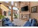Outdoor seating area with stone fireplace, mounted television, and comfortable furnishings at 38 Pebble Dunes Ct, Las Vegas, NV 89141