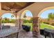 Outdoor kitchen featuring stone columns, granite counters, ceiling fan, and built-in grill at 38 Pebble Dunes Ct, Las Vegas, NV 89141