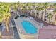 Community pool surrounded by palm trees, lounge chairs, and condos at 5000 Red Rock St # 120, Las Vegas, NV 89118