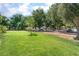 Spacious front lawn featuring green grass and mature trees providing shade, with street parking at 5101 Renault Ave, Las Vegas, NV 89142