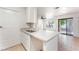 Kitchen featuring white countertops, stainless steel sink, and tile flooring with access to living area at 5101 Renault Ave, Las Vegas, NV 89142